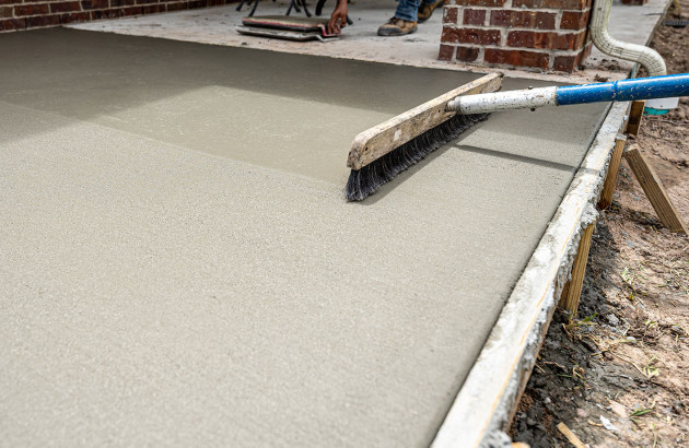 Artisan qui lisse une chape en béton