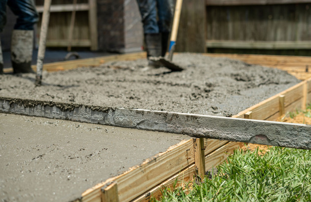 Artisan qui réalise  une dalle en béton