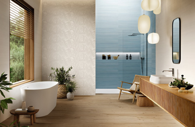 Salle de bains contemporaine avec douche à l’italienne habillée de carrelage bleu, baignoire blanche et mobilier en bois clair.