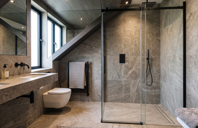 Salle de bains avec des carreaux imitation marbre et paroi
