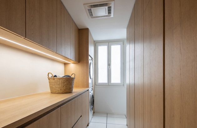Buanderie aménagée avec rangements en bois et ventilation