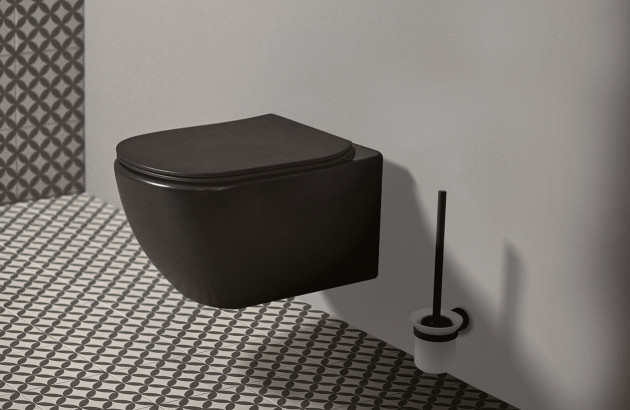 WC suspendu noir mat installé dans un espace aux carreaux graphiques noirs et blancs.