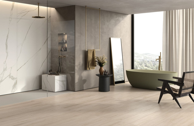 Grande salle de bains de villa avec parquet au sol et carrelage mural effet marbre