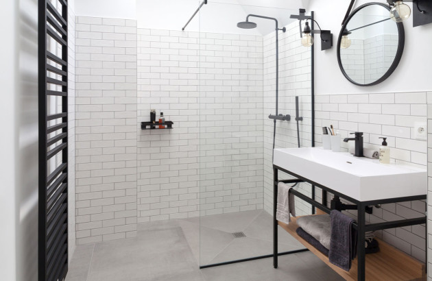 Grande douche italienne dans une salle de bains carrelée en blanc