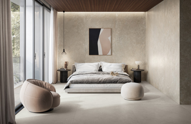 Suite parentale design avec carrelage beige grand format et murs en pierre claire.