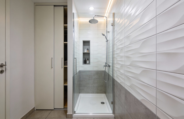 Douche avec placard dans une salle de bains blanche