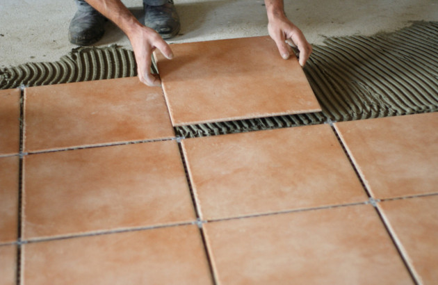 pose de carrelage marron au sol dans une salle de bain