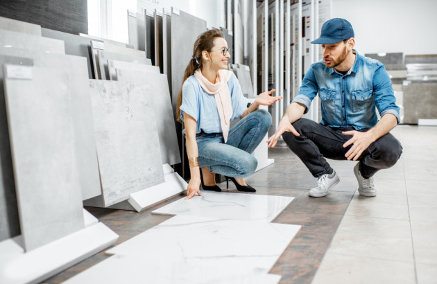 Couple comparant de grands carreaux pour choisir le revêtement adapté à son projet.