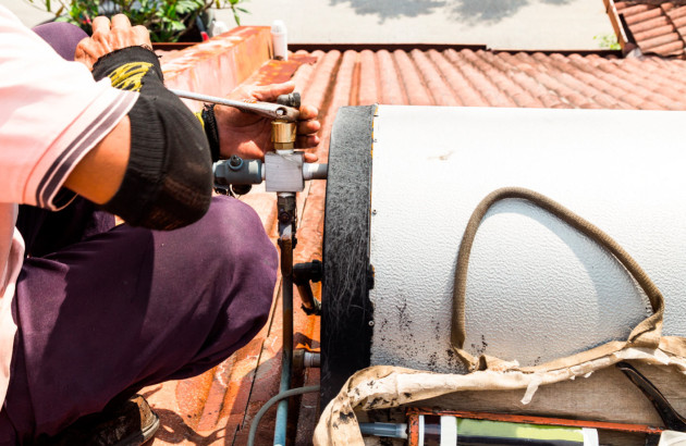 Professionnel qui ajuste la pression du liquide caloporteur dans un système solaire thermique
