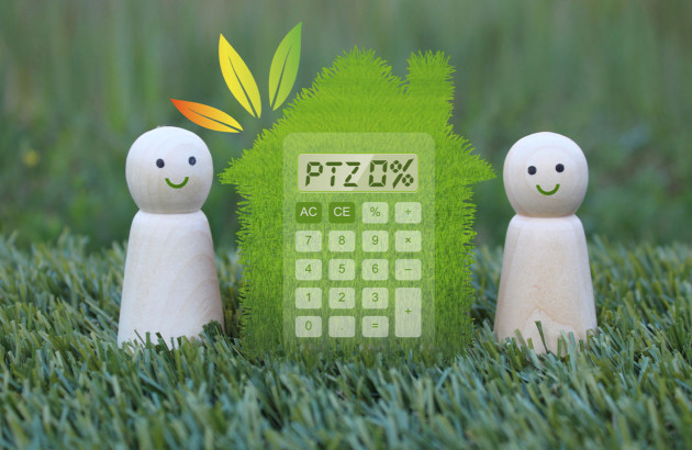 deux figurines en bois qui encadrent une maison verte avec une calculatrice affichant 