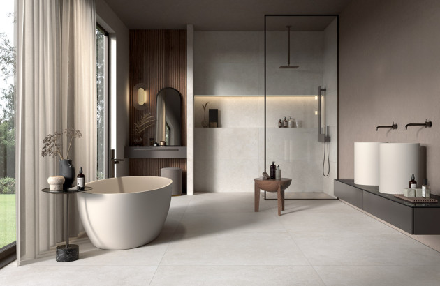 Salle de bains design avec baignoire noire effet marbre et faïence graphique colorée.