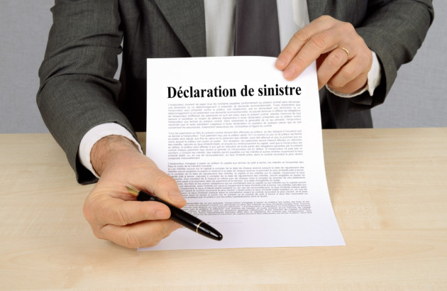 Homme en costume qui tend un papier avec mentionné Déclaration de sinistre