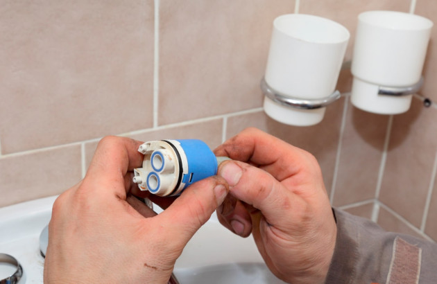 Homme qui change une cartouche de robinet thermostatique