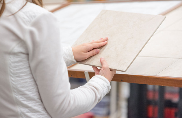 Un femme touche un carreau de carrelage