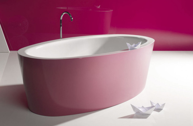 Baignoire îlot ovale au design original mise en valeur dans une salle de bains rose.