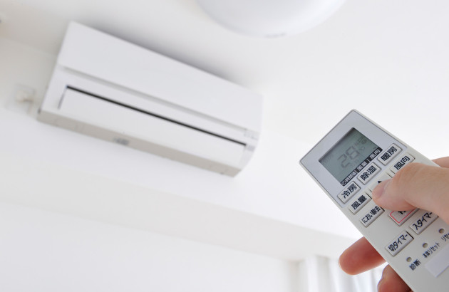 Utilisation d’une télécommande pour régler la température d’une climatisation réversible.