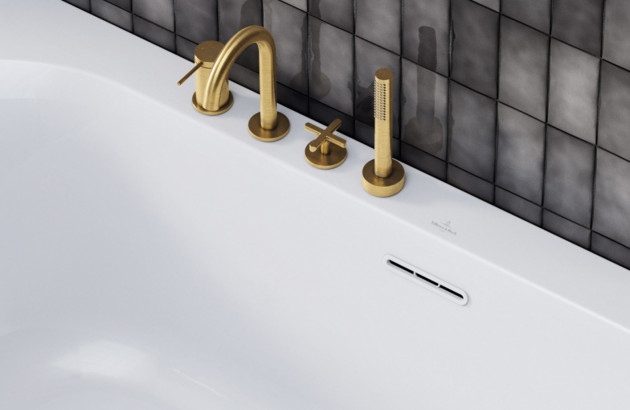 Trop-plein horizontal d'une baignoire blanche avec robinetterie couleur or