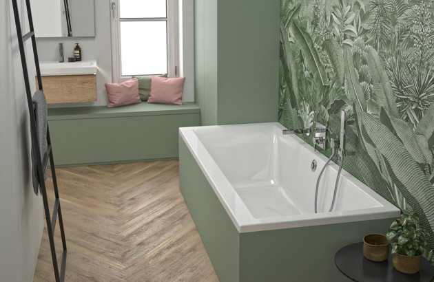 Baignoire rectangulaire blanche intégrée dans une salle de bains verte avec papier peint végétal.
