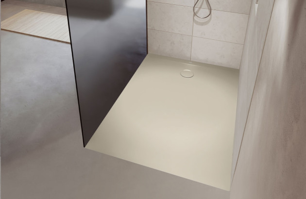 Douche à l’italienne équipée d’un receveur extra-plat blanc et d’une paroi en verre fumé pour un rendu minimaliste.