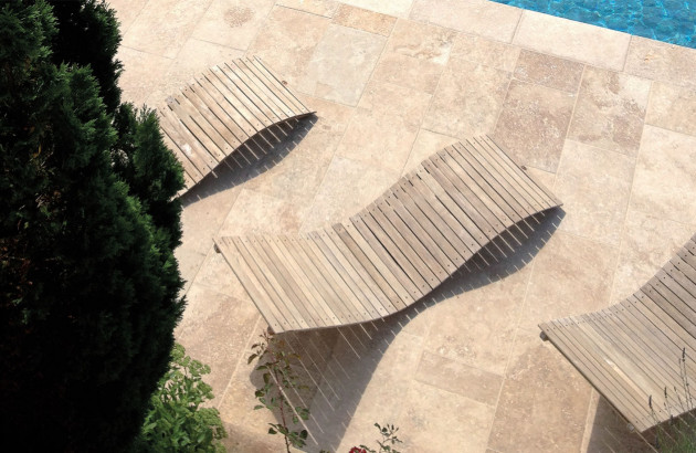 terrasse en pierre naturelle au bord d'une piscine