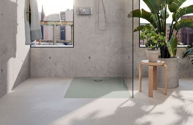 Receveur de douche extra-plat intégré au sol dans une salle de bains lumineuse au style industriel et végétal.