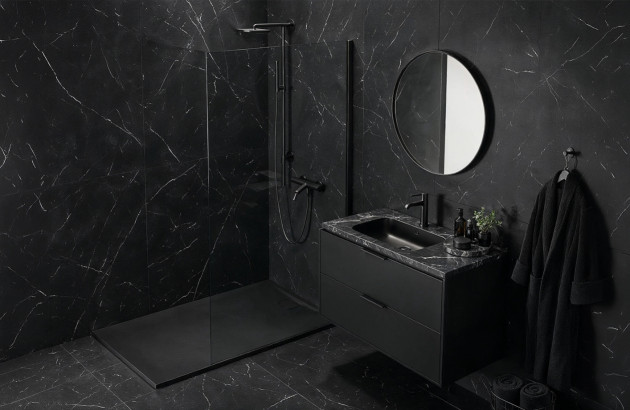Salle de bains noire avec douche ouverte et meuble vasque.