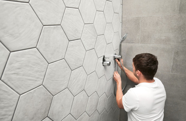 Homme en train de travailler sur le remplacement d'un mitigeur de douche