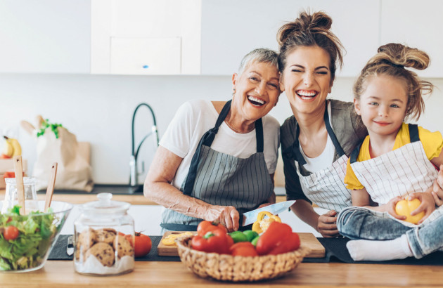 Trois personnes en train de cuisiner en souriant