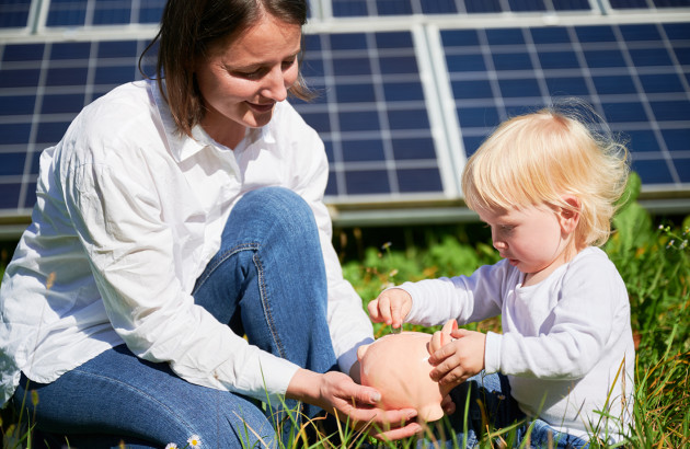 Famille devant des panneaux solaires avec tirelire