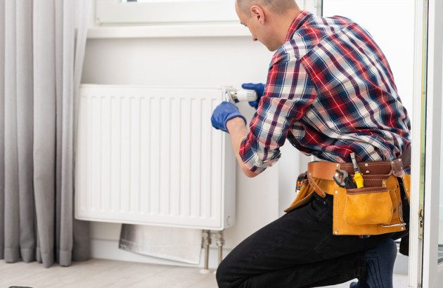 Homme qui intervient sur un radiateur