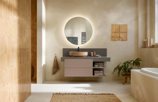 Salle de bains chaleureuse aux tons naturels avec meuble vasque suspendu, miroir rond rétroéclairé et baignoire.