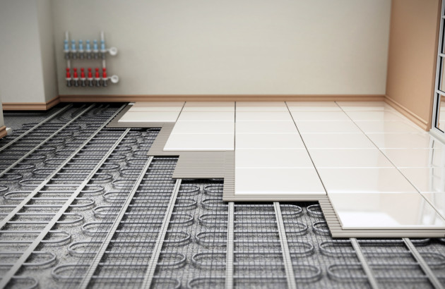 Carreaux de carrelage en train d'être posés sur un plancher chauffant
