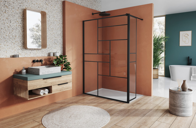 Douche à l’italienne équipée d’une paroi noire, dans une salle de bains aux tons orange
