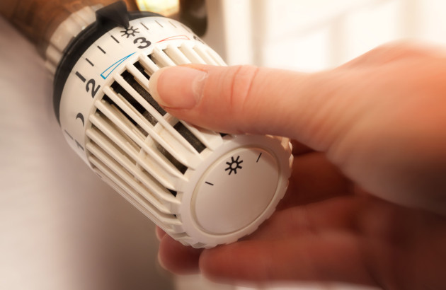 Personne qui utilise un robinet thermostatique de chauffage