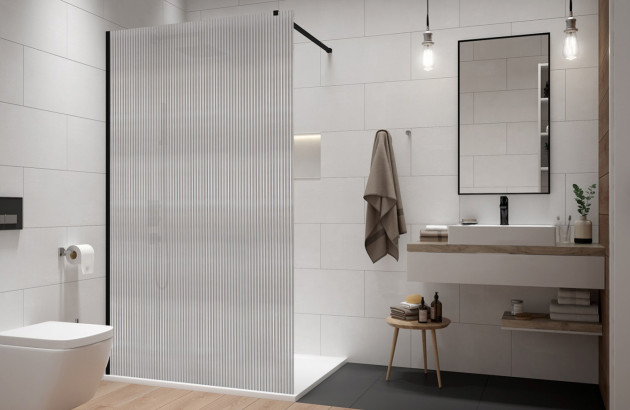 salle de bain lumineuse aux murs blancs et douche à l'italienne dotée d'une paroi en verre strié avec toilette et meuble-lavabo avec vasque blanche et robinetterie noire