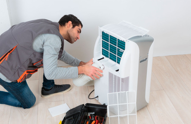 homme qui installe un climatiseur mobile
