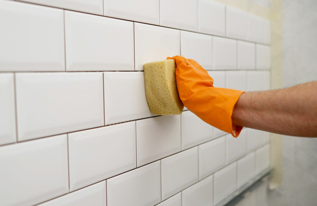 Personne qui essuie le carrelage de sa salle de bains