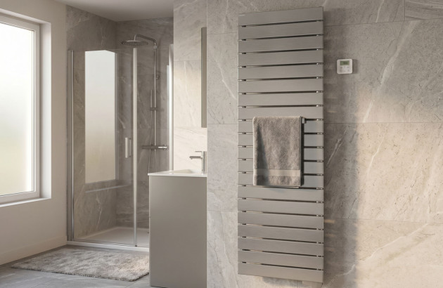 Sèche-serviettes mural blanc dans une salle de bains moderne avec douche à l’italienne et carrelage effet pierre.