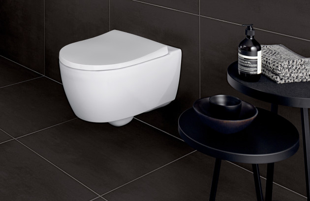 WC suspendu blanc dans une salle d’eau sombre avec mobilier noir, ambiance moderne et élégante