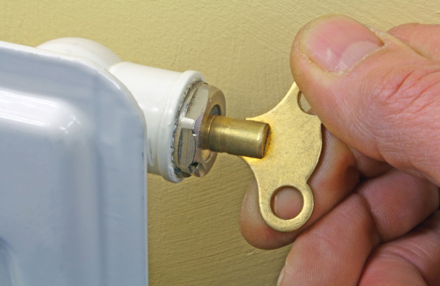 Personne qui démarre une procédure de purge de radiateur