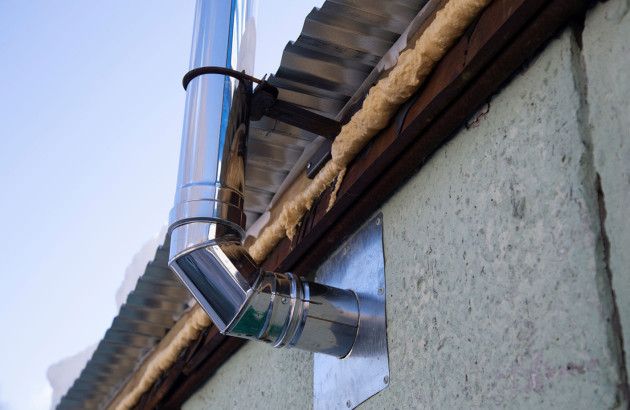 Conduit de cheminée qui sort de la facade d'une maison