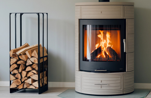 Buchettes de bois entreposées dans un range buches à côté d'un poêle à bois en fonctionnement