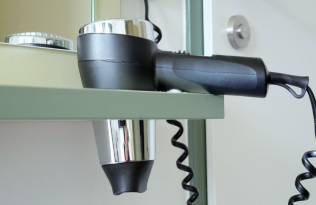 Support et prise sèche cheveux dans une armoire de salle de bains