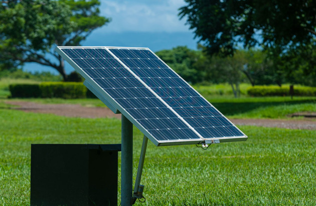 Panneaux solaires au sol sur un poteau.