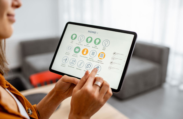 Femme qui utilise une tablette domotique