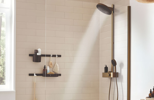 Douche moderne avec colonne noire et finition bronze dans un espace lumineux aux accents naturels.