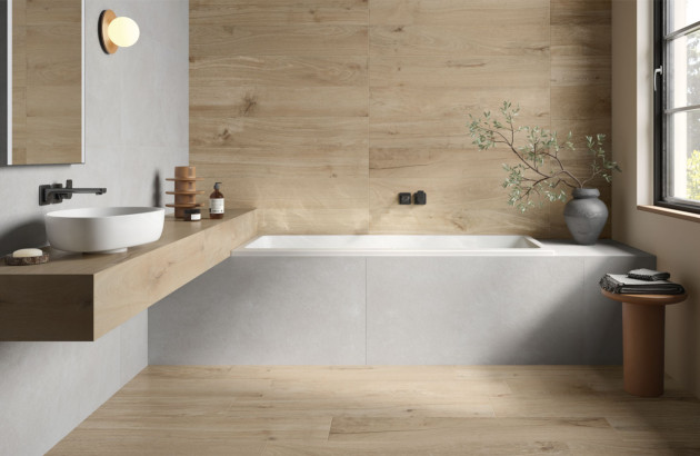 Baignoire dans une salle de bains avec du carrelage aux couleurs naturelles