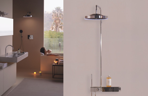 Espace bien-être contemporain avec baignoire près d’une grande fenêtre et colonne de douche design au premier plan.