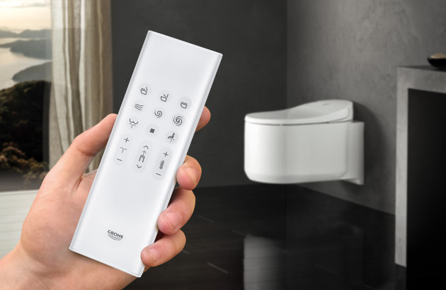 Personne qui tient une télécommande grohe qui contrôle des toilettes