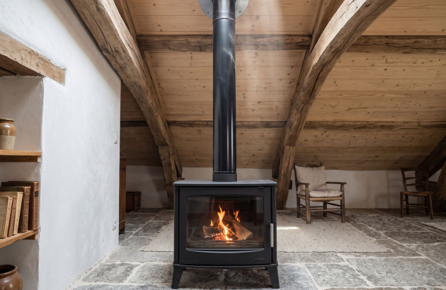 Poêle à bois en fonctionnement sous les combles
